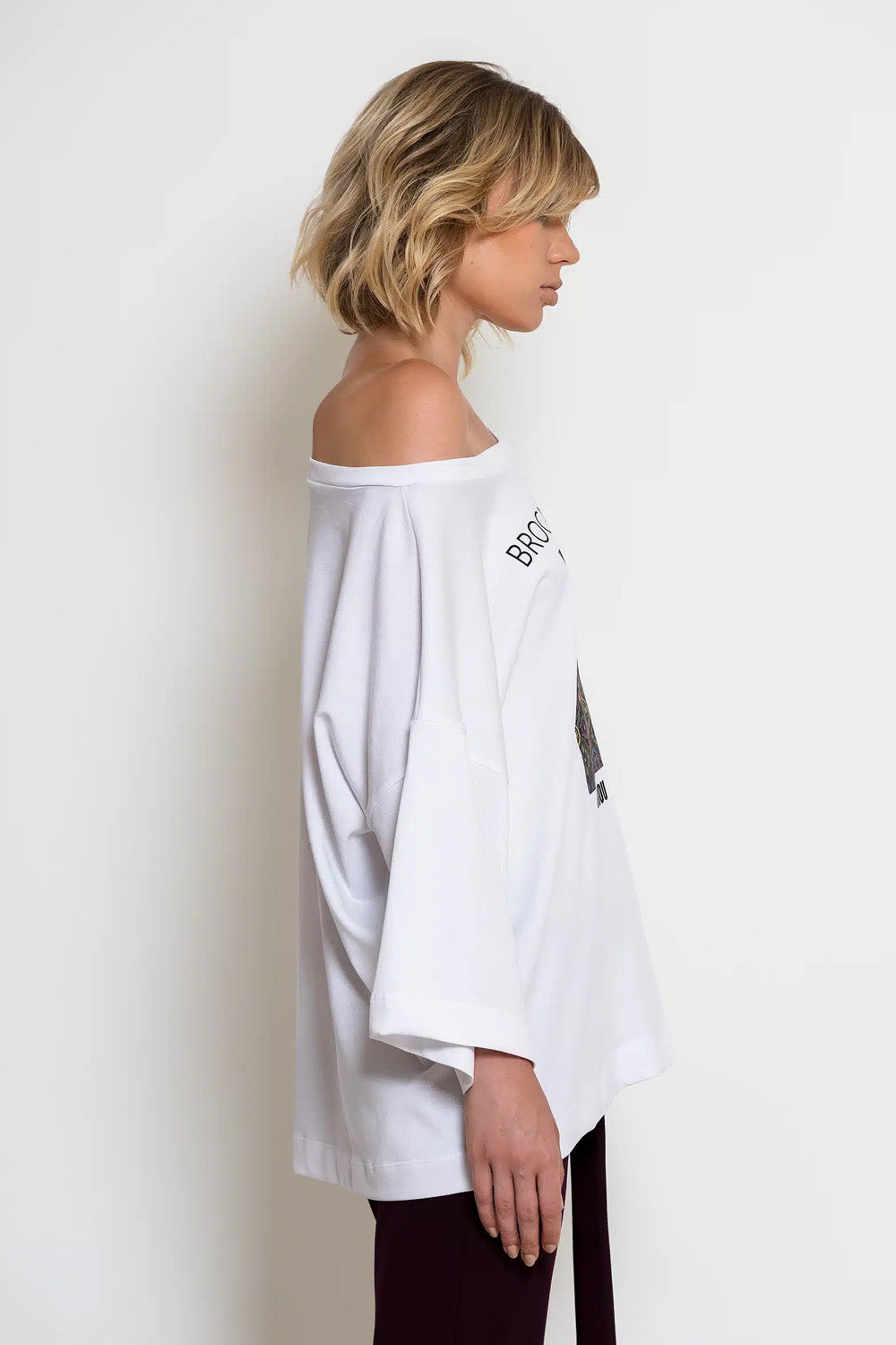 Λευκό oversized T-shirt C-THROU με φαρδιά λαιμόκοψη, ασύμμετρα μανίκια και πολύχρωμη στάμπα.