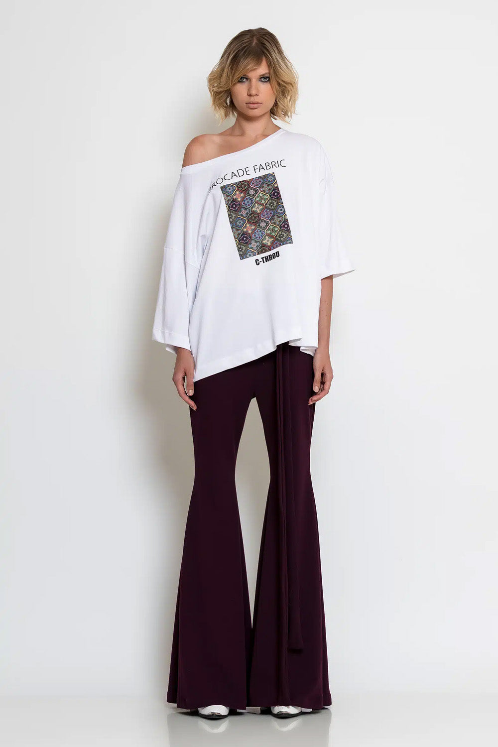 Λευκό oversized T-shirt C-THROU με φαρδιά λαιμόκοψη, ασύμμετρα μανίκια και πολύχρωμη στάμπα.