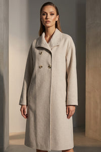 Εκρού παλτό με διπλό κούμπωμα και ίσια γραμμή, φορεμένο από μοντέλο.