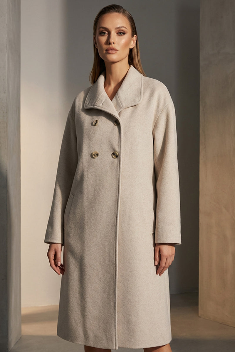 Εκρού παλτό με διπλό κούμπωμα και ίσια γραμμή, φορεμένο από μοντέλο.