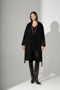 Μαύρο παλτό με χρυσές κεντημένες λεπτομέρειες, άνετη γραμμή, ζώνη στη μέση και κομψά μανίκια.