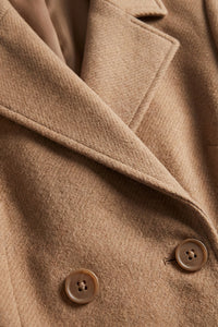 Ταμπά παλτό με ζώνη στη μέση και διπλό κούμπωμα, φορεμένο από μοντέλο.
