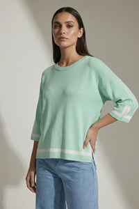 Πλεκτή μπλούζα μέντα με λευκή ρίγα στο τελείωμα και μανίκι 3/4, ίσια γραμμή με πλαϊνά ανοίγματα.