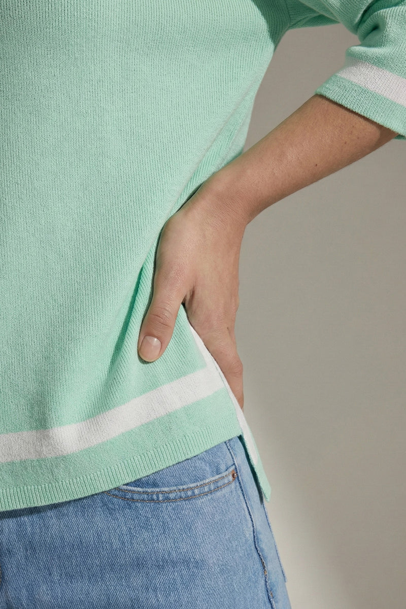 Πλεκτή μπλούζα μέντα με λευκή ρίγα στο τελείωμα και μανίκι 3/4, ίσια γραμμή με πλαϊνά ανοίγματα.