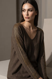 Καφέ πλεκτή μπλούζα με V λαιμόκοψη και χρυσές λεπτομέρειες σε ώμους και μανίκια, φορεμένη από μοντέλο studio.