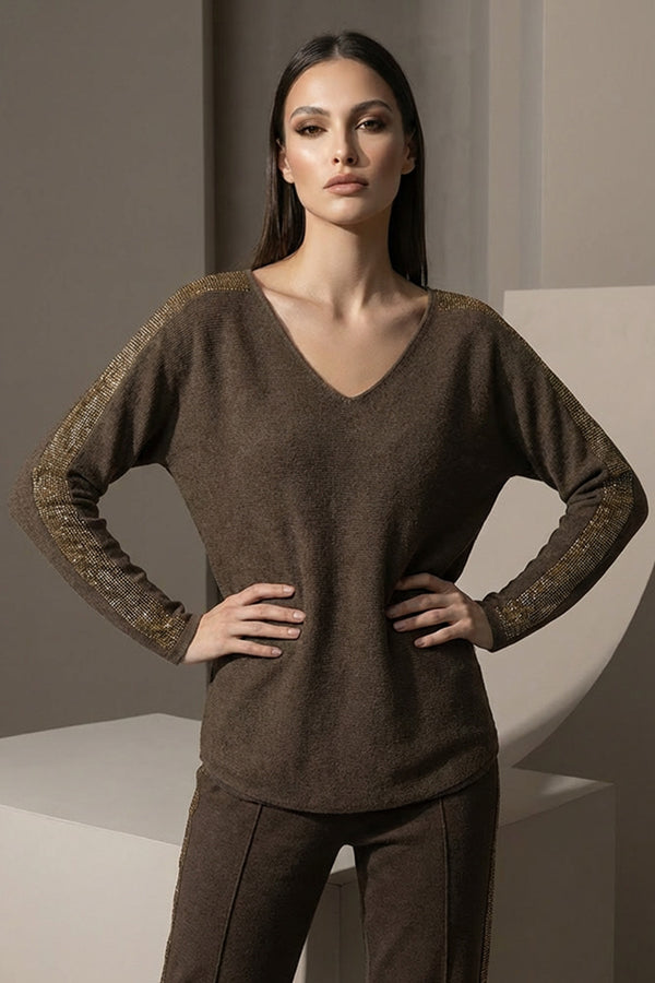 Καφέ πλεκτή μπλούζα με V λαιμόκοψη και χρυσές λεπτομέρειες σε ώμους και μανίκια, φορεμένη από μοντέλο studio.