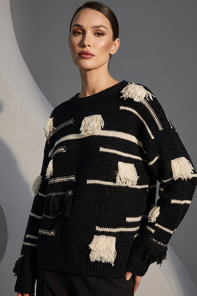 Μαύρη πλεκτή μπλούζα με εκρού ρίγες και διακοσμητικά κρόσσια, φορεμένη από μοντέλο σε studio φόντο.