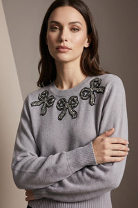 Γκρι πλεκτή μπλούζα με διακοσμητικό κέντημα στο μπροστινό μέρος, φορεμένη σε μοντέλο.