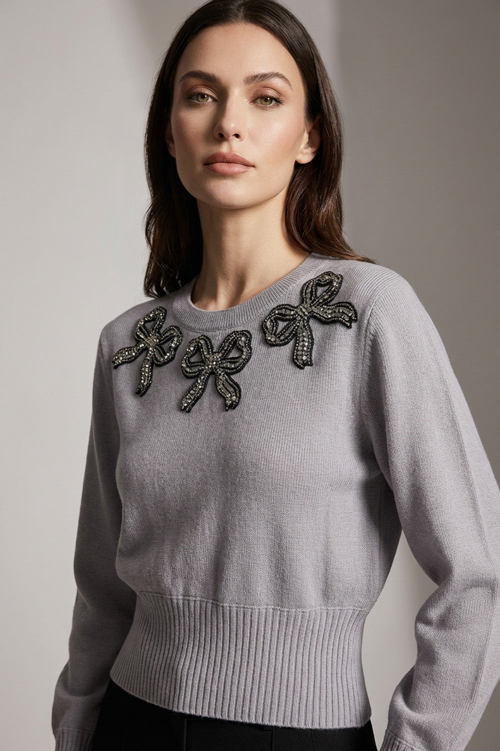 Γκρι πλεκτή μπλούζα με διακοσμητικό κέντημα στο μπροστινό μέρος, φορεμένη σε μοντέλο.