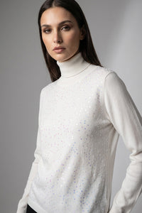 Πλεκτή μπλούζα εκρού ζιβάγκο με διακριτική παγιέτα στο μπροστινό μέρος και μακριά μανίκια, σε κομψή άνετη γραμμή.