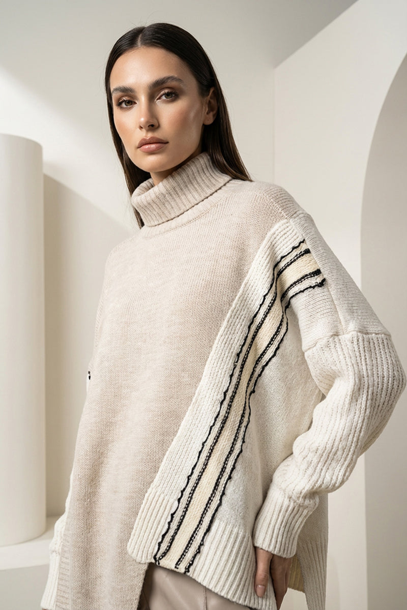 Πλεκτή εκρού μπλούζα ζιβάγκο με contrast μανίκια και γραμμικές λεπτομέρειες, φορεμένη από μοντέλο.