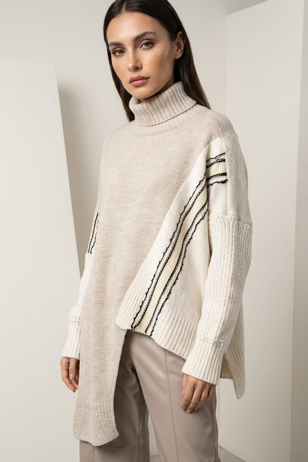 Πλεκτή εκρού μπλούζα ζιβάγκο με contrast μανίκια και γραμμικές λεπτομέρειες, φορεμένη από μοντέλο.