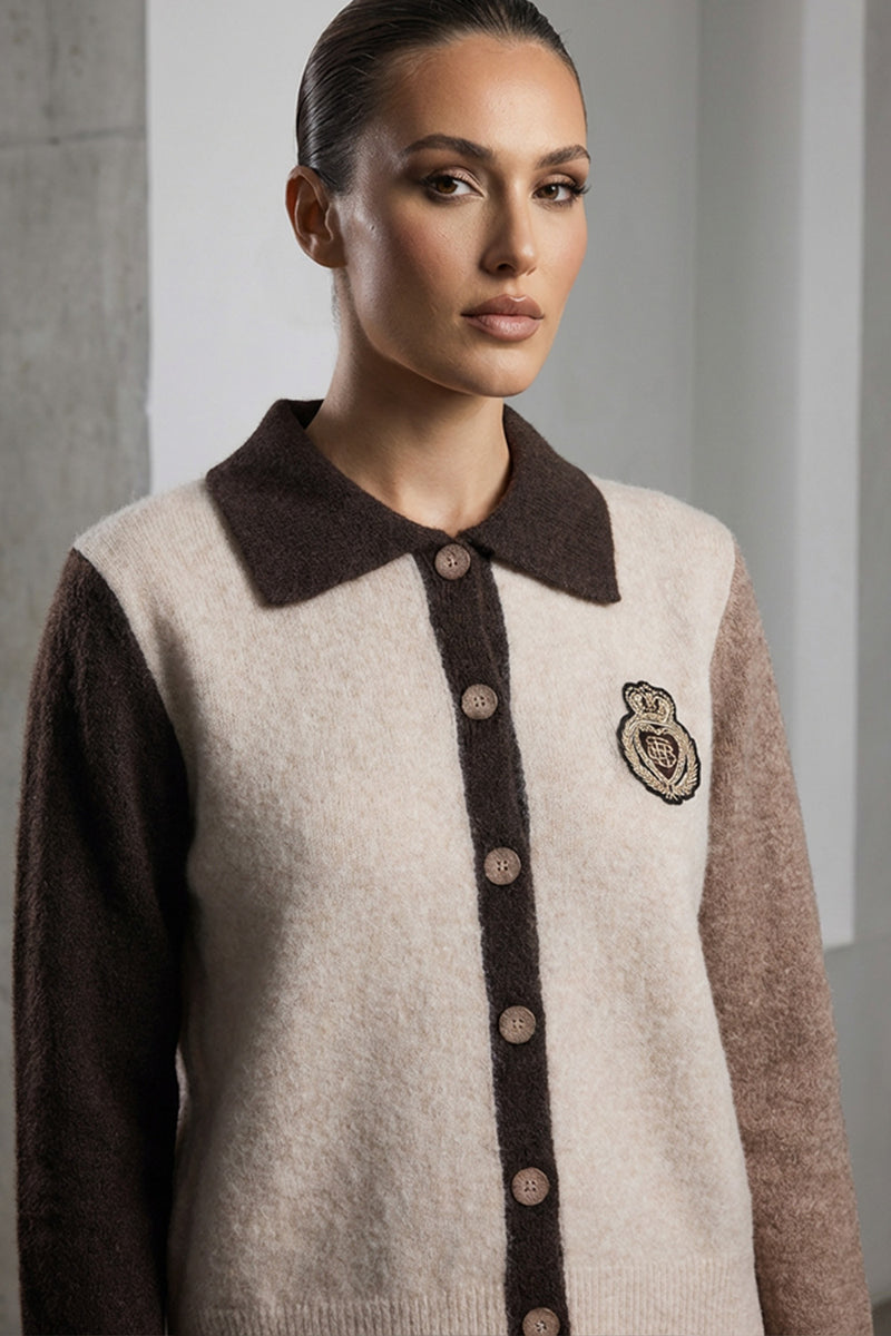 Πλεκτή ζακέτα colourblock με γιακά, κουμπιά και κεντημένο σήμα σε γήινες αποχρώσεις σε μοντέλο studio.