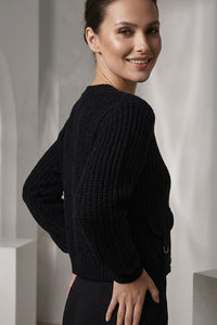 Γυναικεία πλεκτή ζακέτα σε μαύρο χρώμα με κουμπιά, V λαιμόκοψη και διακοσμητικές μπροστινές τσέπες.