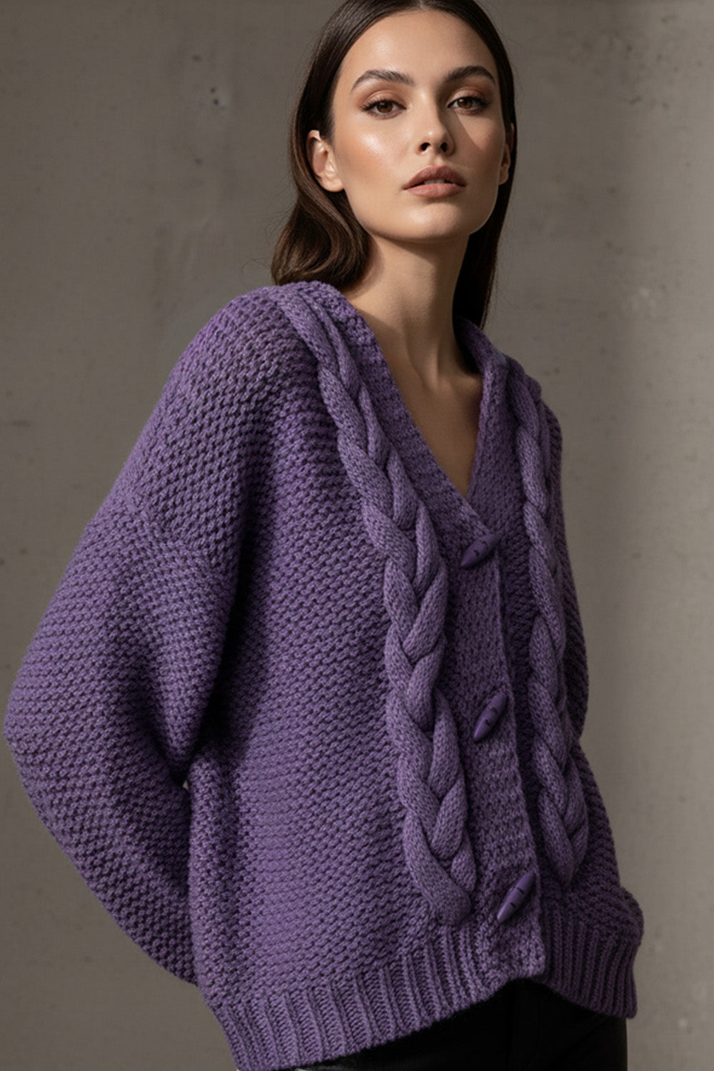 Πλεκτή γυναικεία ζακέτα με πλεξούδες και V ντεκολτέ σε μωβ απόχρωση, φορεμένη σε μοντέλο.