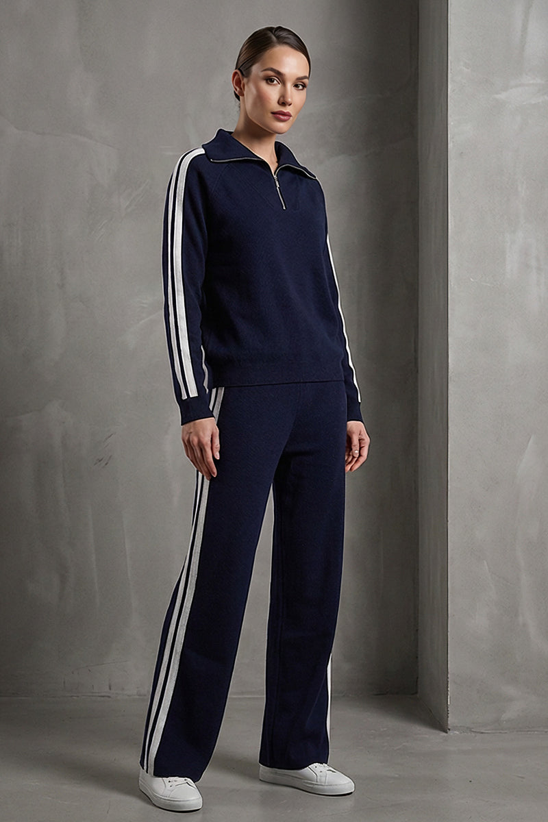 Μπλε πλεκτό σετ με λευκές ρίγες σε μανίκια και παντελόνι, με φερμουάρ στον λαιμό, φορεμένο από μοντέλο studio.