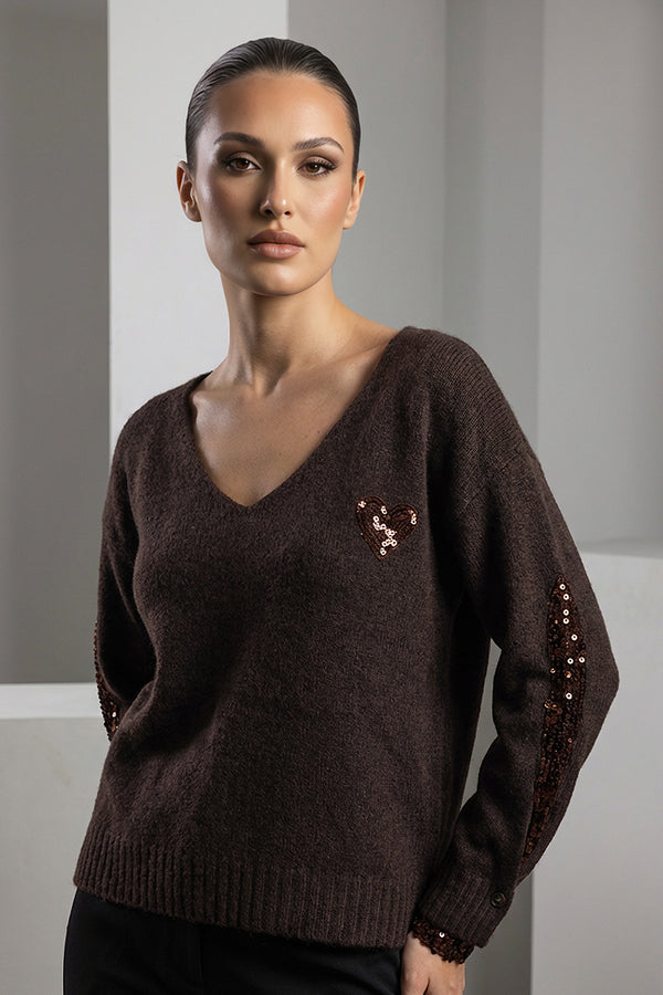 Πλεκτό σοκολατί με V λαιμόκοψη και μπρονζέ παγιέτες σε καρδιά και μανίκια, φορεμένο από μοντέλο studio.
