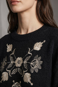 Μαύρο πλεκτό πουλόβερ με κεντημένο floral σχέδιο σε εκρού αποχρώσεις, φορεμένο από μοντέλο.