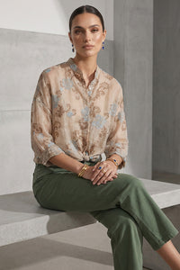 Γυναικείο διάφανο μπεζ πουκάμισο με floral διακοσμητικό σχέδιο και χαλαρή γραμμή, φορεμένο με πράσινο παντελόνι.