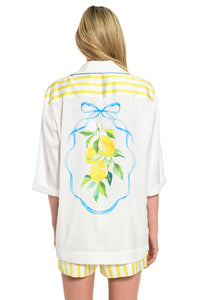 Λευκό γυναικείο πουκάμισο Lemon Breeze με print λεμονιών στην πλάτη, γαλάζιες λεπτομέρειες και διακοσμητικό κόσμημα στην τσέπη.