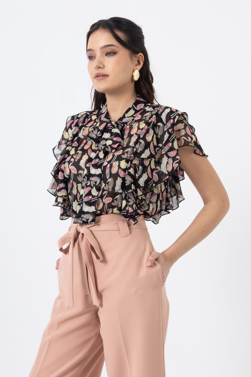 μαύρο πουκάμισο με πολύχρωμο print, βολάν και δέσιμο στον λαιμό σε συνδυασμό με ψηλόμεσο παντελόνι