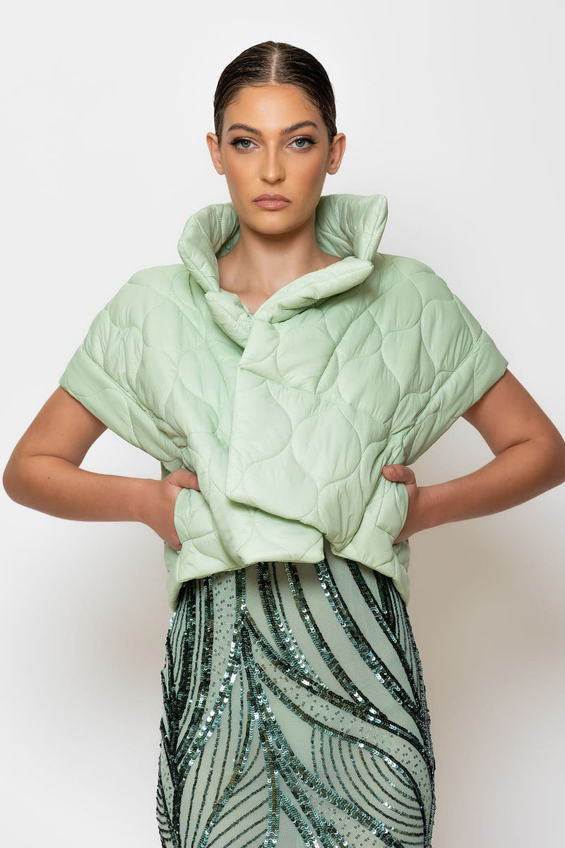 Cropped puffer jacket in light green, featured with a stylish collar, paired with a sequined skirt for a chic look.