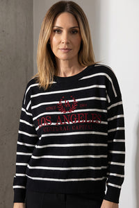 Γυναικείο μαύρο ριγέ πλεκτό με λευκές ρίγες και κεντημένο σχέδιο στο μπροστινό μέρος, φορεμένο από μοντέλο.