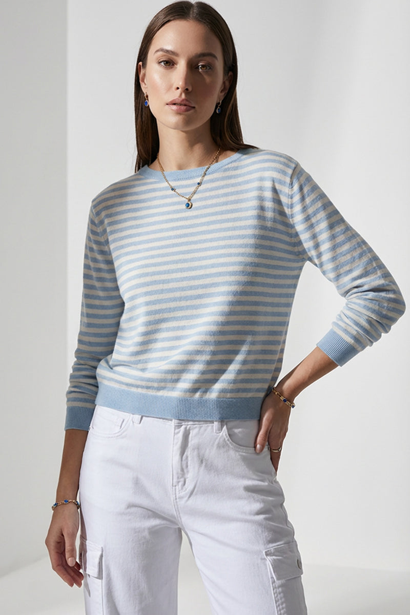 Γυναικείο ριγέ πλεκτό μπλουζάκι σε γαλάζιο και εκρού με μακρύ μανίκι και ελαστική πλέξη, φορεμένο με λευκό cargo παντελόνι.
