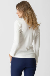 Λευκή ριπ μπλούζα με βολάν στο πέτο και μακρύ μανίκι, εφαρμοστή γραμμή, φορεμένη από μοντέλο σε studio φόντο