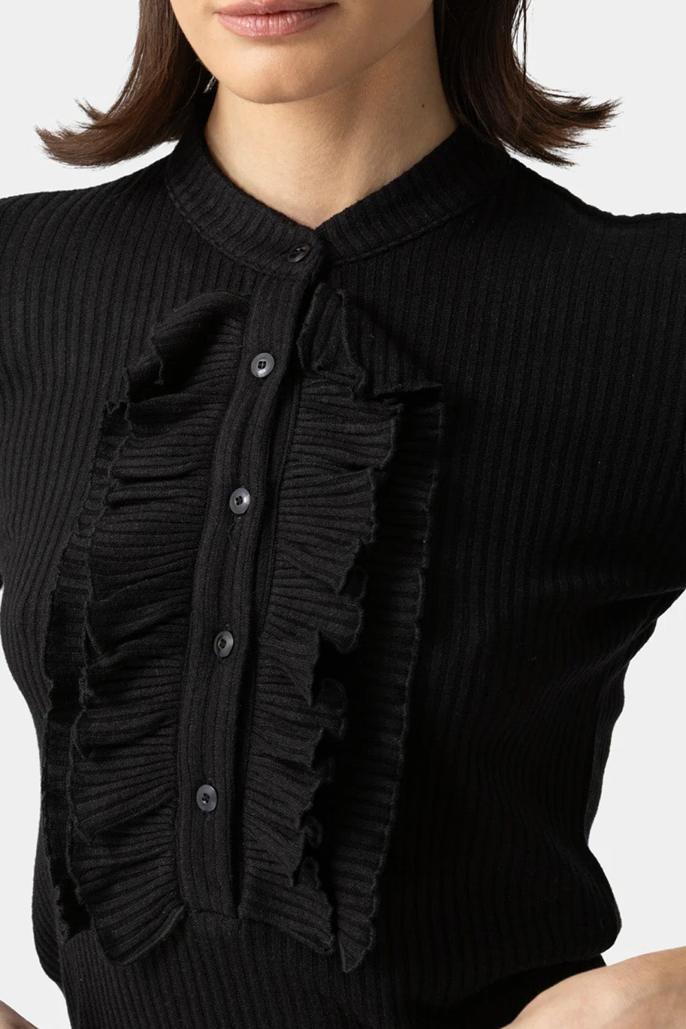 Μαύρη ριπ μπλούζα με βολάν στο πέτο και κουμπιά, εφαρμοστή γραμμή, φορεμένη από μοντέλο σε studio φόντο