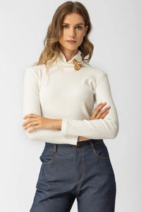 Εκρού ριπ μπλούζα ζιβάγκο με διακοσμητικό κόσμημα σε χρυσό τόνο, εφαρμοστή γραμμή, φορεμένη από μοντέλο σε studio φόντο