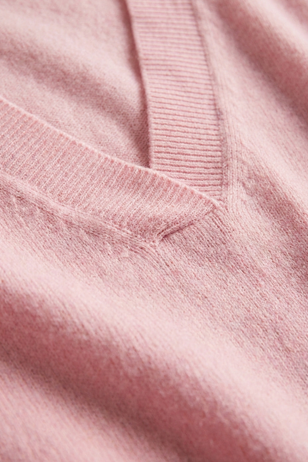 Ροζ πλεκτή μπλούζα με V λαιμόκοψη και απαλή υφή σε γυναικείο μοντέλο