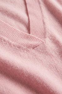 Ροζ πλεκτή μπλούζα με V λαιμόκοψη και απαλή υφή σε γυναικείο μοντέλο