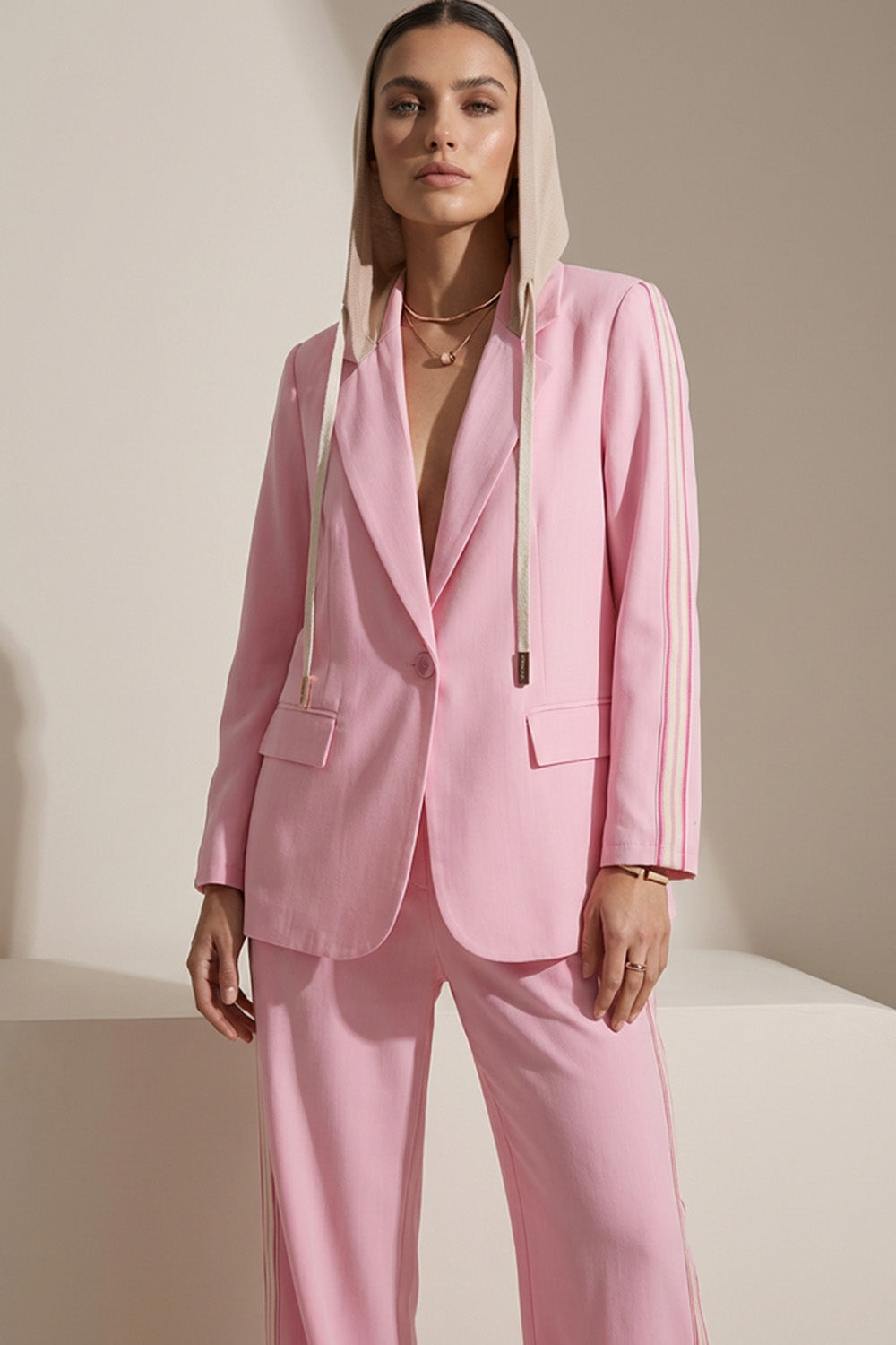 Ροζ γυναικείο σετ με σακάκι με κουκούλα και ίσιο παντελόνι με πλαϊνές ρίγες