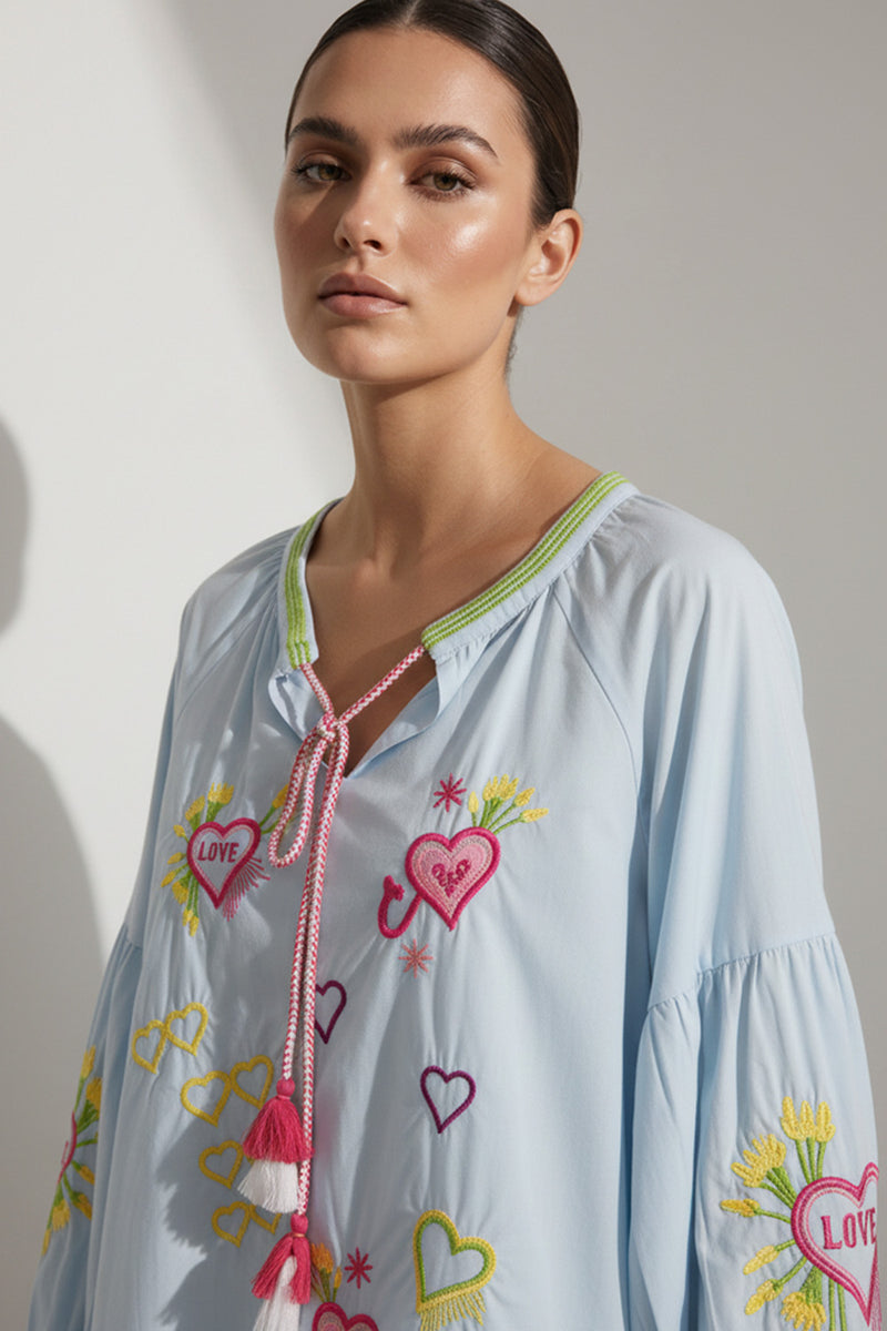 Σιέλ γυναικεία μπλούζα με κέντημα καρδιές, V λαιμόκοψη με κορδόνι και μακριά balloon μανίκια.