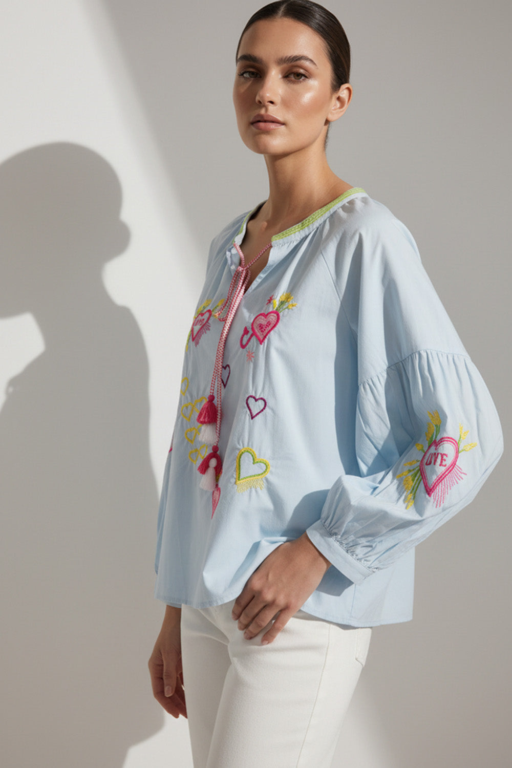 Σιέλ γυναικεία μπλούζα με κέντημα καρδιές, V λαιμόκοψη με κορδόνι και μακριά balloon μανίκια.