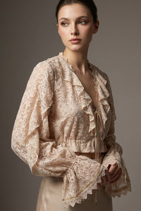 Εκρου δαντελένιο τοπ iRous με βολάν, μακριά μανίκια και χρυσό κέντημα στην πλάτη, φωτογράφιση σε στούντιο.