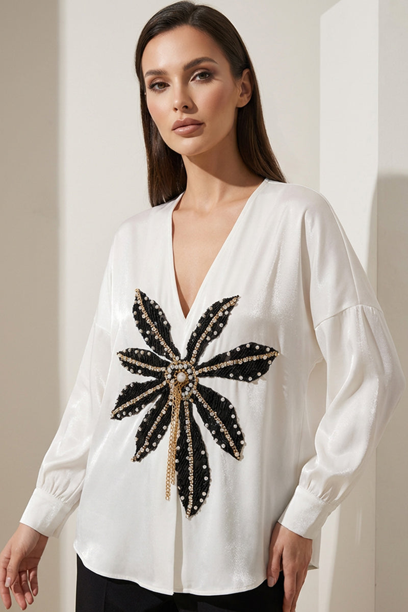 Εκρού γυναικεία βελούδινη μπλούζα με V λαιμό και διακοσμητικό μοτίβο σε μαύρο και χρυσό.