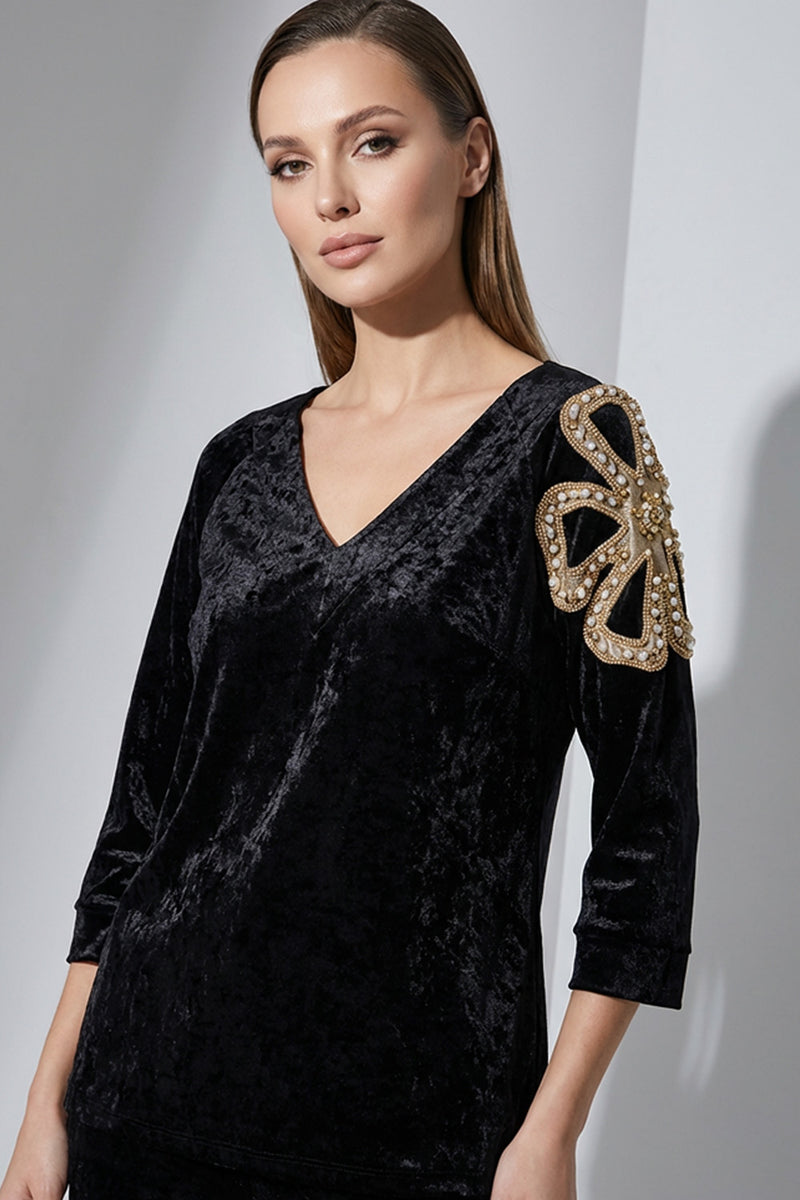 Μαύρη γυναικεία βελούδινη μπλούζα με V λαιμό και διακοσμητικό μοτίβο στον ώμο.