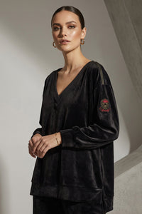 βελούδινη μπλούζα με V λαιμόκοψη και διακοσμητικό τύπωμα λιονταριού στην πλάτη, φορεμένη σε μοντέλο.