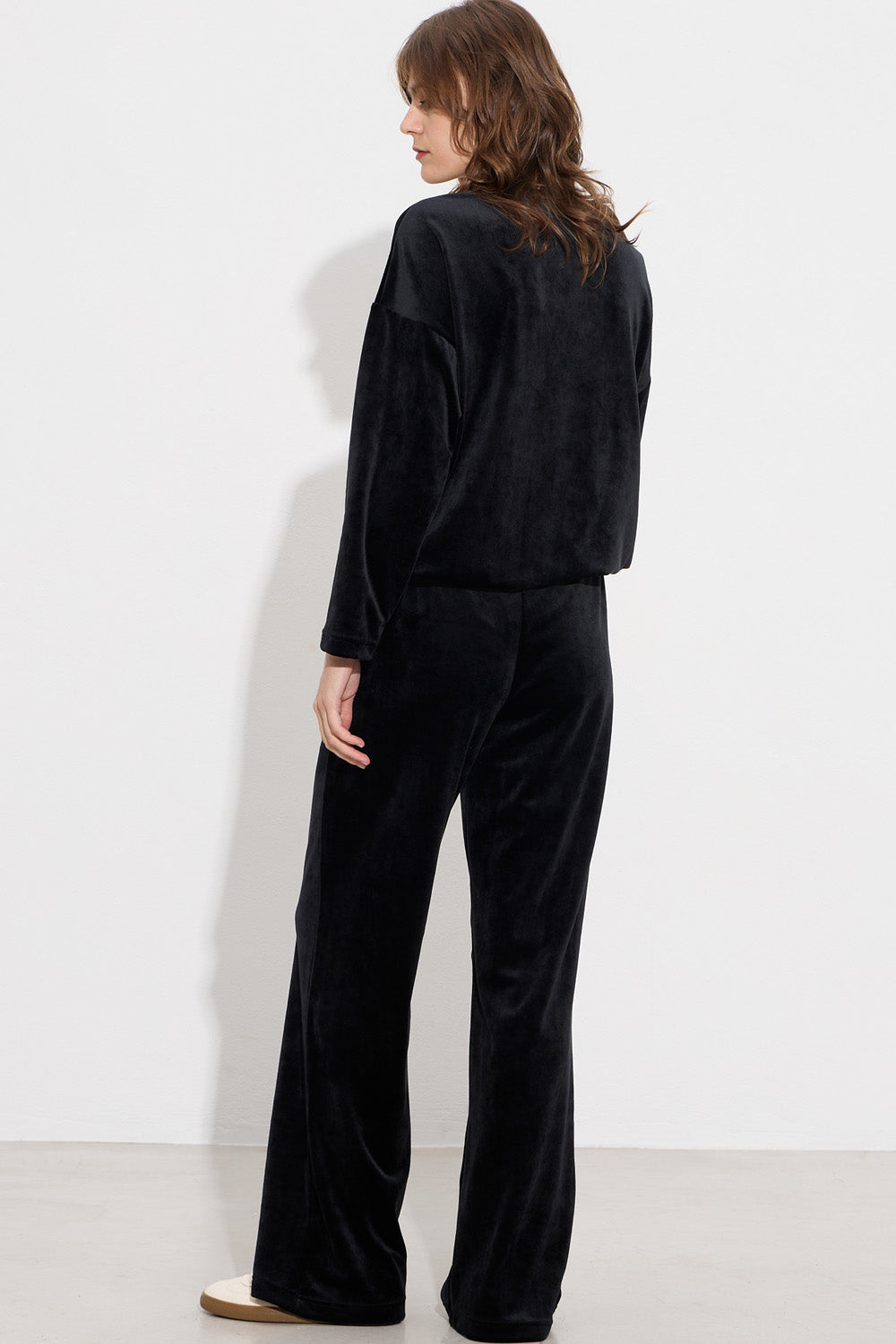 Μαύρο γυναικείο βελούδινο σετ με μακρυμάνικη μπλούζα και παντελόνι ίσιας γραμμής.