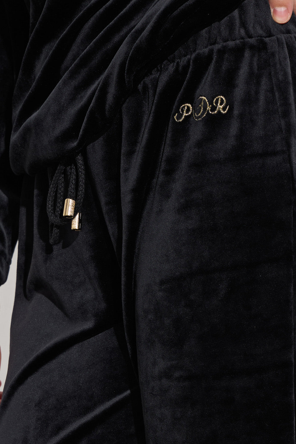 Μαύρο γυναικείο βελούδινο σετ με μακρυμάνικη μπλούζα και παντελόνι ίσιας γραμμής.