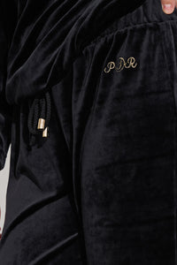 Μαύρο γυναικείο βελούδινο σετ με μακρυμάνικη μπλούζα και παντελόνι ίσιας γραμμής.