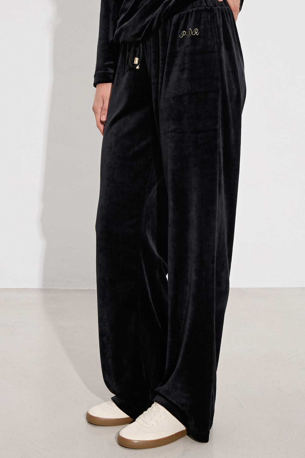 Μαύρο γυναικείο βελούδινο σετ με μακρυμάνικη μπλούζα και παντελόνι ίσιας γραμμής.