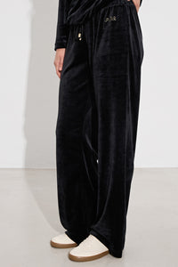 Μαύρο γυναικείο βελούδινο σετ με μακρυμάνικη μπλούζα και παντελόνι ίσιας γραμμής.