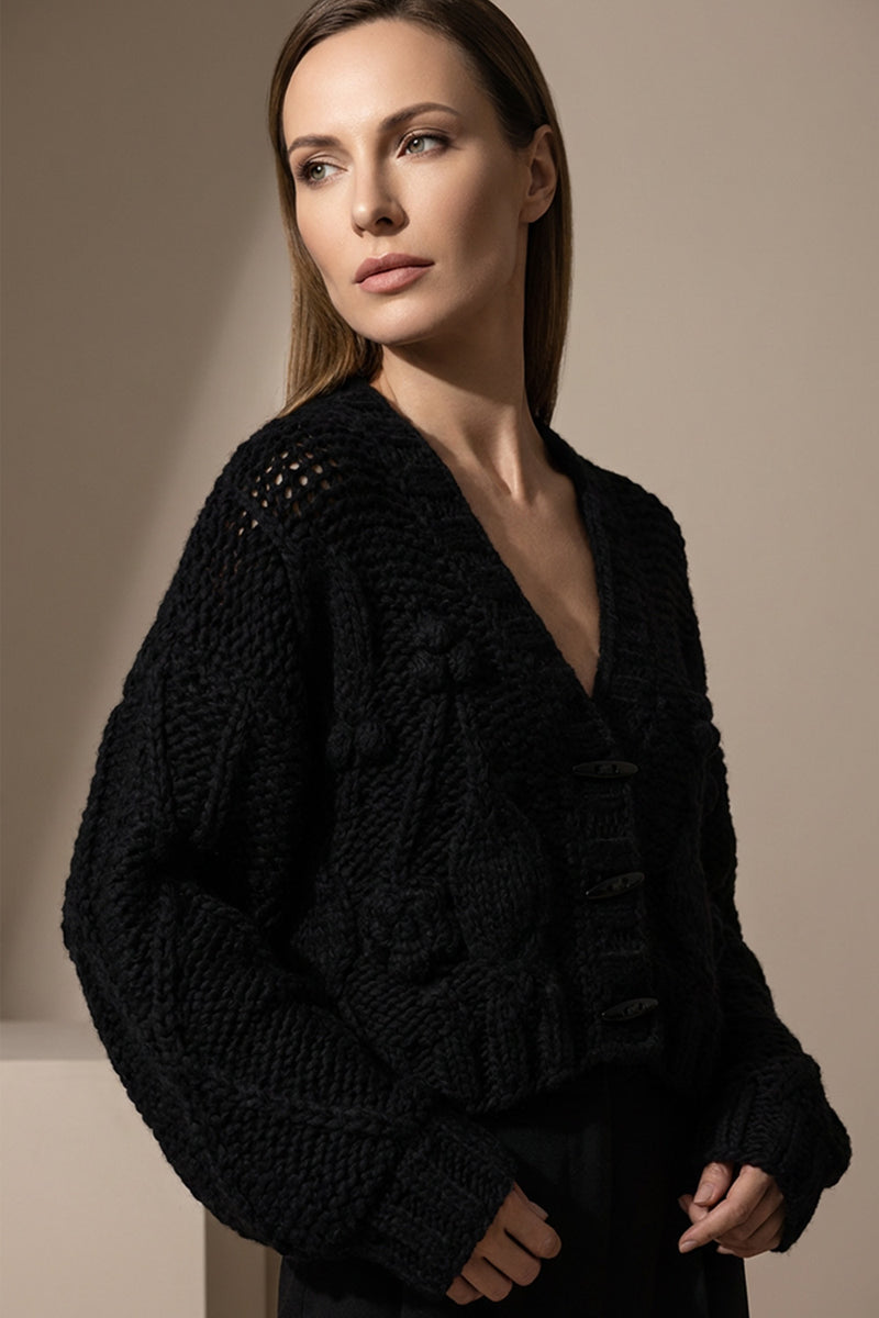 Χοντρή πλεκτή ζακέτα μαύρη με ανάγλυφη πλέξη, V λαιμόκοψη και κουμπιά, σε άνετη γραμμή για χειμερινά σύνολα.
