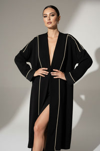 Μαύρη μακριά ζακέτα με εκρού κάθετες ραφές και άνετη, minimal γραμμή.