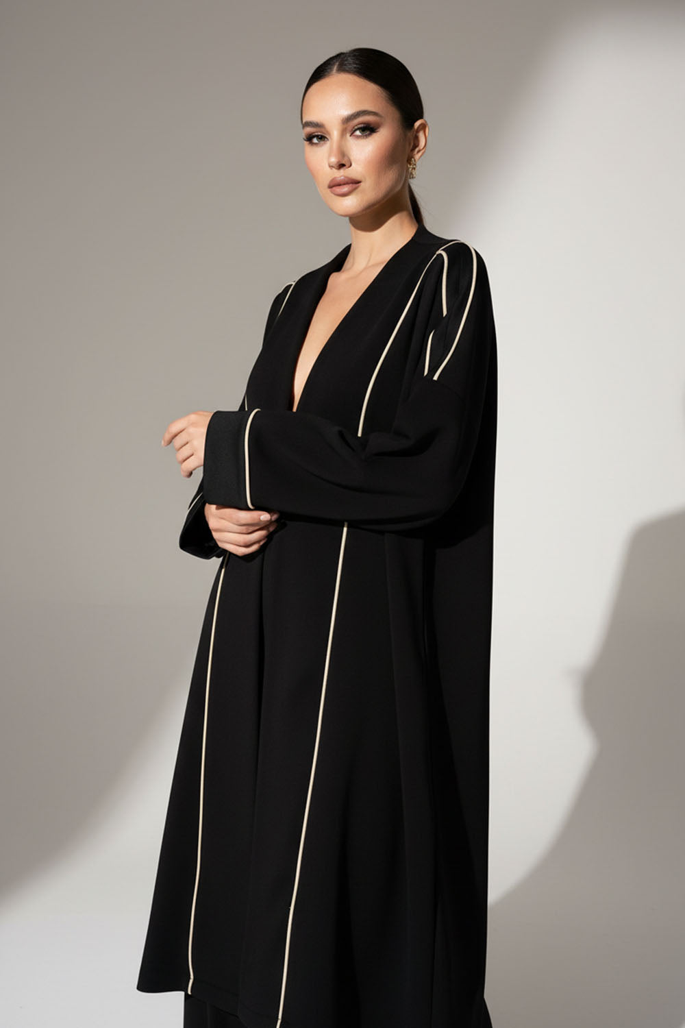 Μαύρη μακριά ζακέτα με εκρού κάθετες ραφές και άνετη, minimal γραμμή.