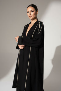 Μαύρη μακριά ζακέτα με εκρού κάθετες ραφές και άνετη, minimal γραμμή.